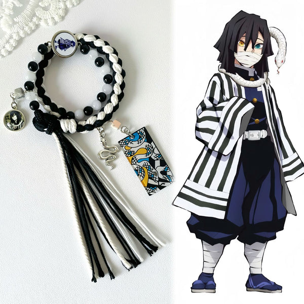 Black and white Obanai Iguro braided bracelet with tassels beside character artwork